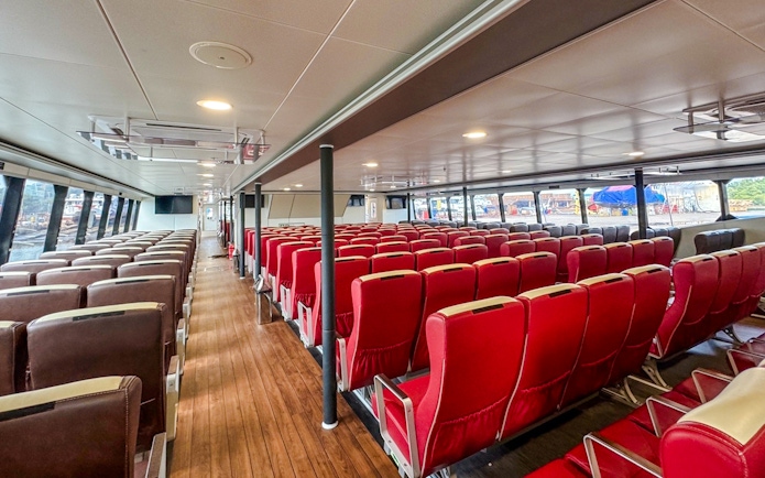 Ferry interior with rows of red and brown seats, Singapore to Bintan route.