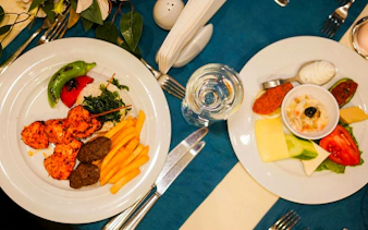 Turkish dinner plates with kebabs, fries, and appetizers on Bosphorus Dinner Cruise, Istanbul.