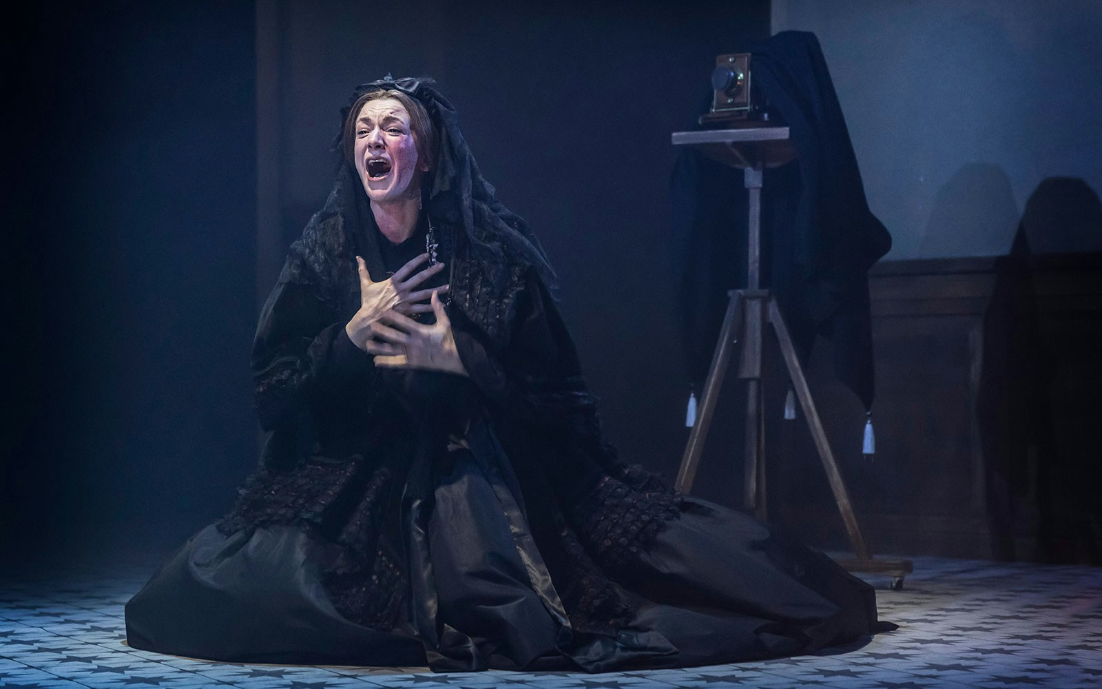 Performer in dramatic pose during "Mrs President" stage production.