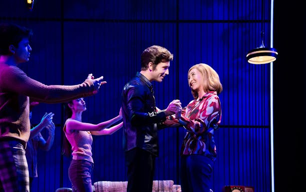 Actors performing a scene from "A Beautiful Noise: The Neil Diamond Musical" on stage.