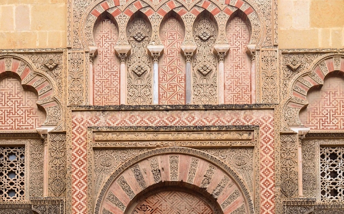 Side gate of Mezquita Cathedral in Cordoba with intricate Moorish designs.