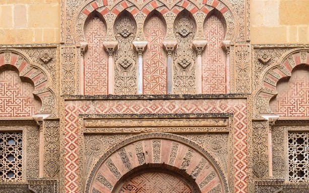 Side gate of Mezquita Cathedral in Cordoba with intricate Moorish designs.