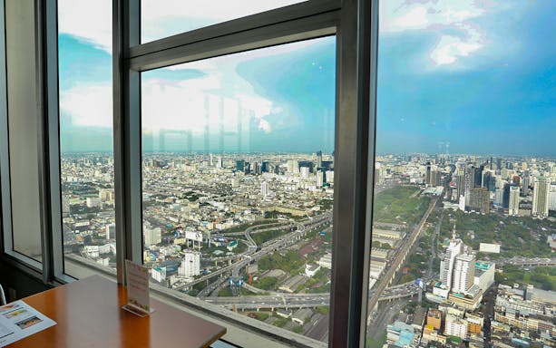 View of Bangkok skyline from Baiyoke Sky Hotel dining area.