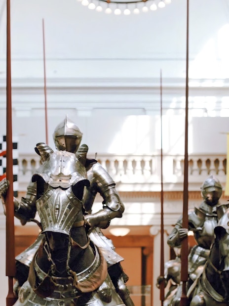 Three suits of 16th-century German field armor for knights on horseback displayed in a museum.
