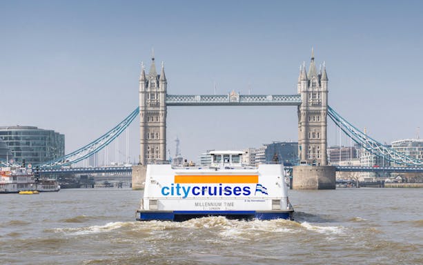 City cruise boat on the Thames with Tower Bridge in London.