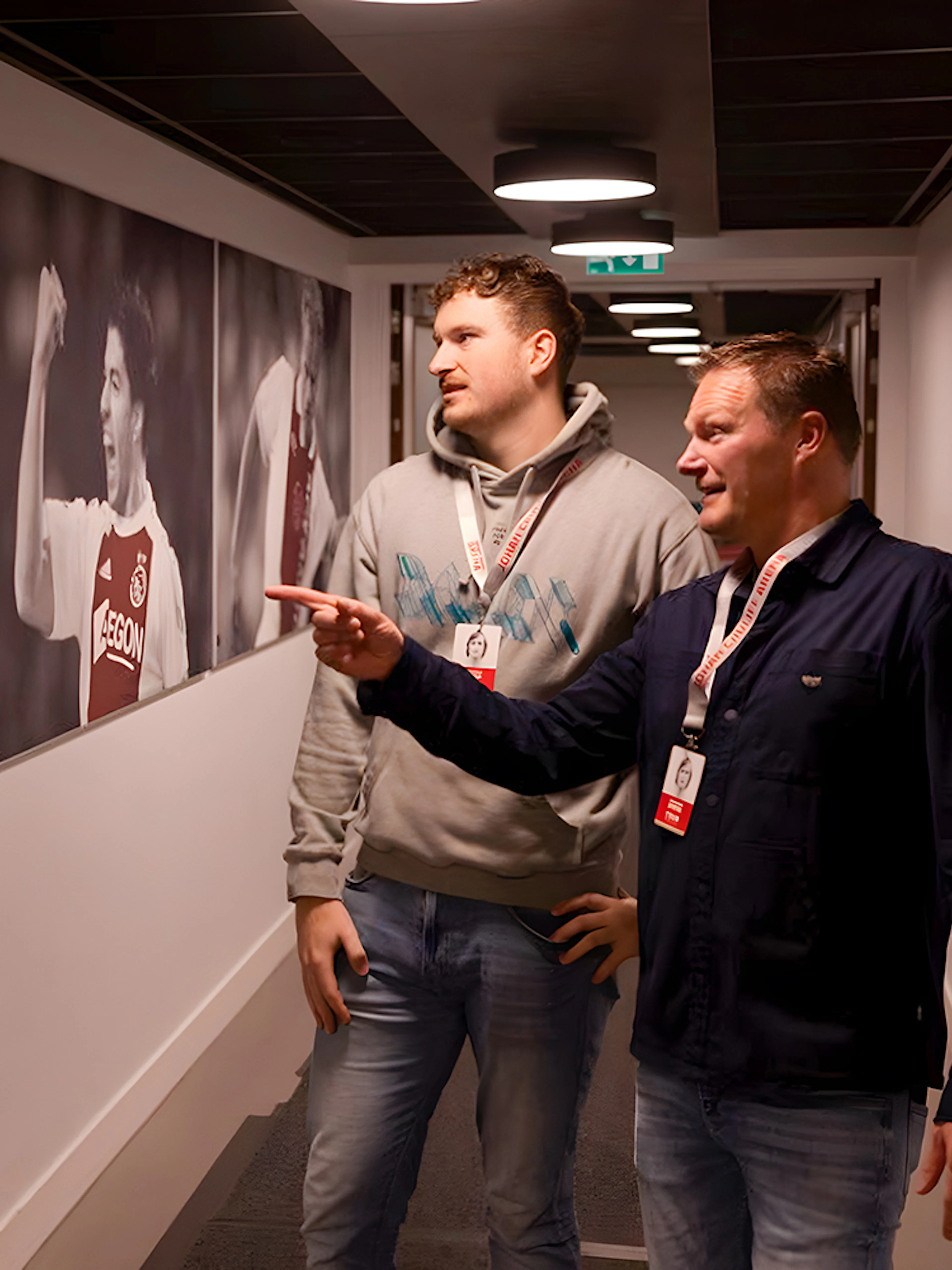 Visitors admire football player photos at Johan Cruijff ArenA Classic Tour.