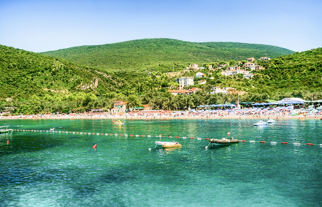Zanjic Beach in Montenegro with clear blue waters and surrounding lush greenery.
