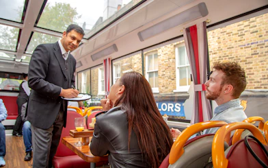 Server taking orders on a London afternoon tea bus tour.