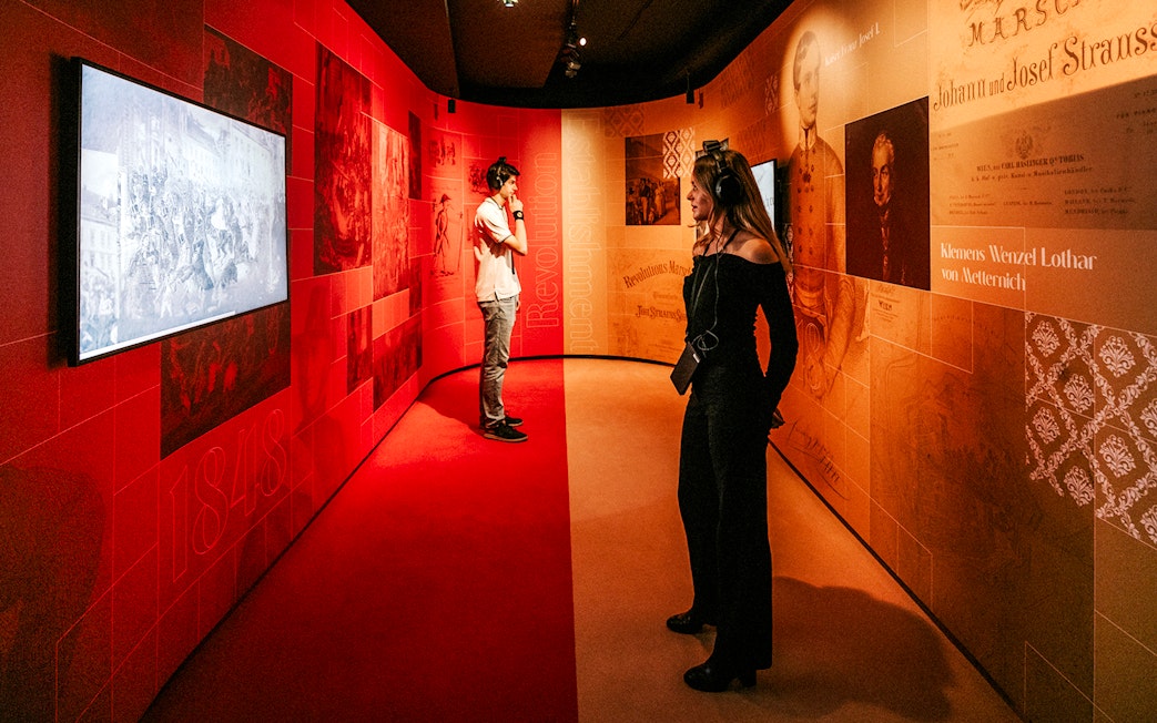 Visitors exploring the Johann Strauss Museum in Vienna, viewing interactive exhibits.