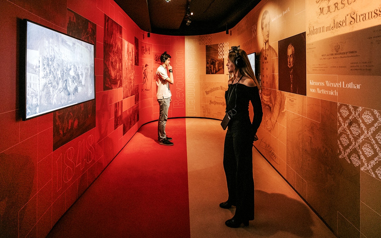 Visitors exploring the Johann Strauss Museum in Vienna, viewing interactive exhibits.