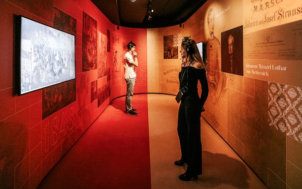 Visitors exploring the Johann Strauss Museum in Vienna, viewing interactive exhibits.