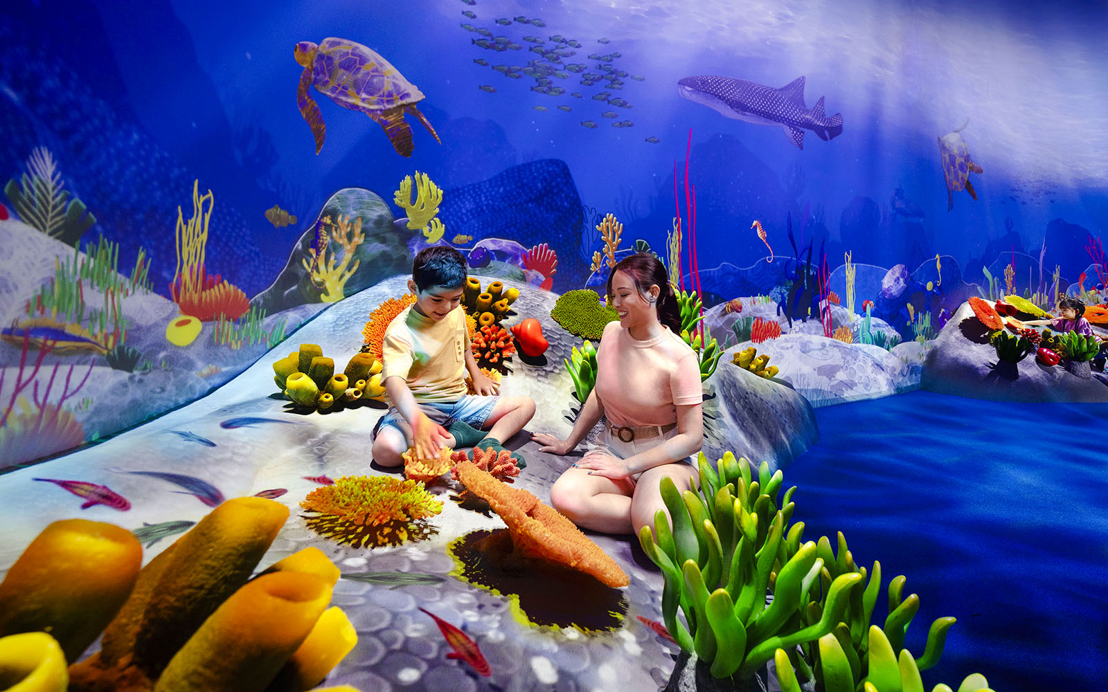 Children exploring vibrant coral reef at Curiosity Cove Wetlands Reef Retreat.