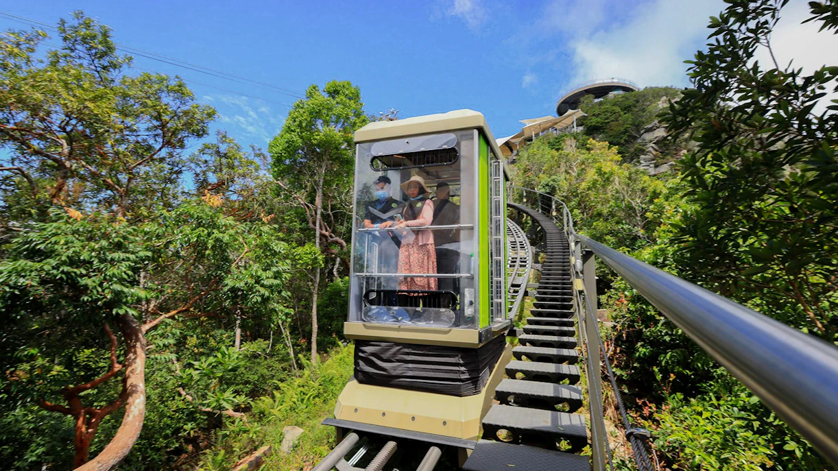 Tourist riding SkyGlide through lush forest in Langkawi.