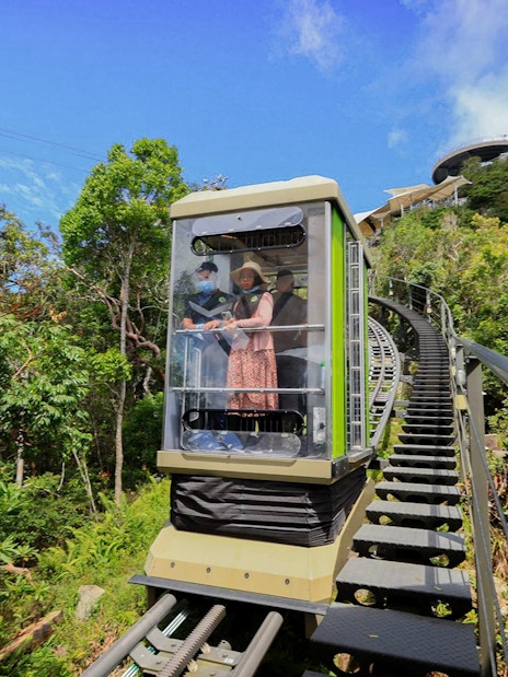 Tourist riding SkyGlide through lush forest in Langkawi.