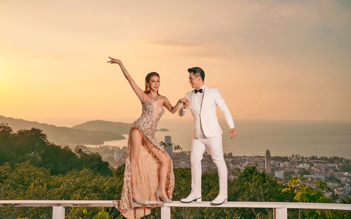 Performers at Simon Cabaret Show with Phuket cityscape in the background.