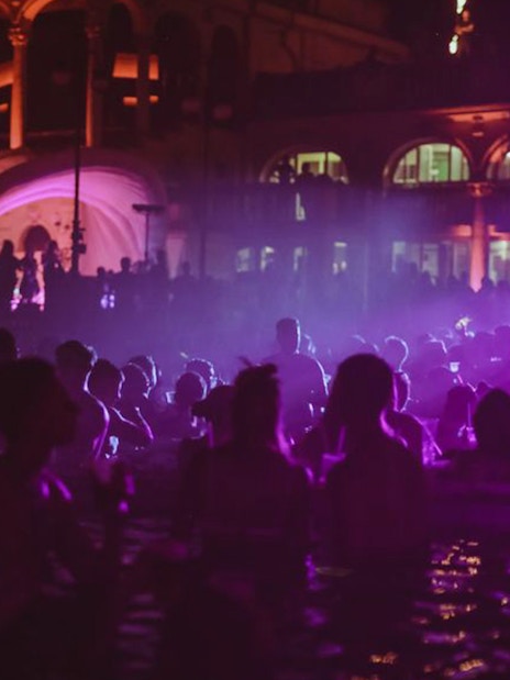 Budapest night party cruise with people enjoying music and lights.