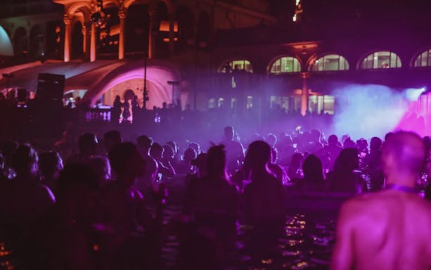 Budapest night party cruise with people enjoying music and lights.