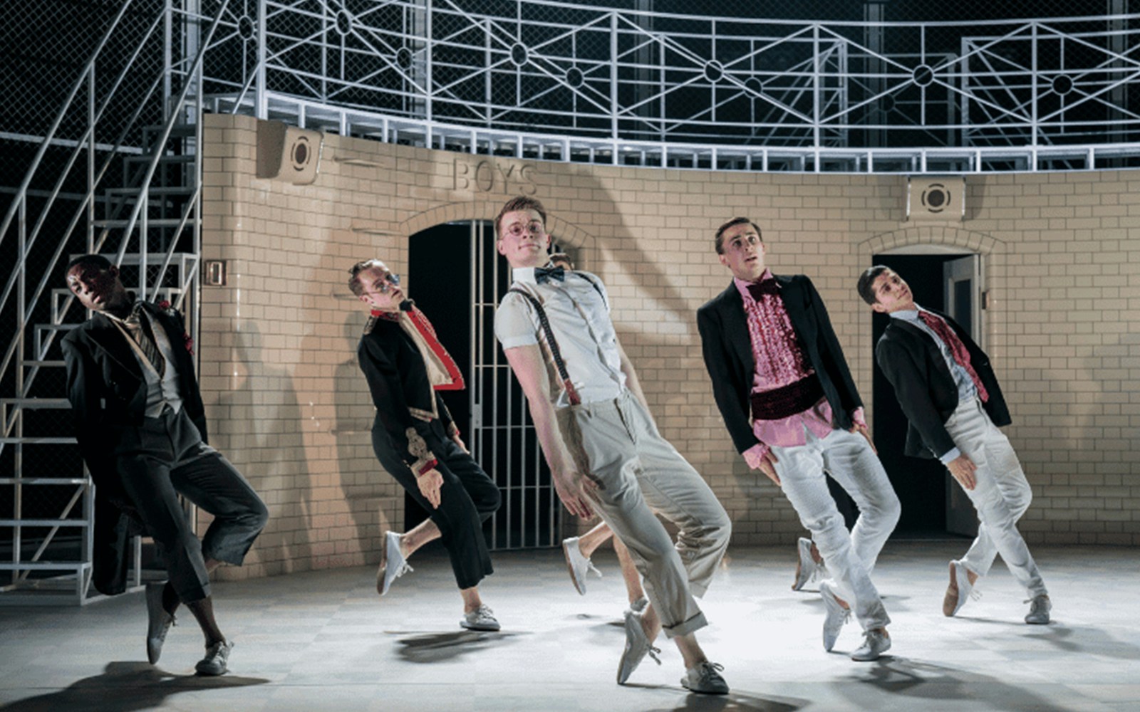 Dancers performing in Matthew Bourne's Romeo and Juliet against a brick backdrop.