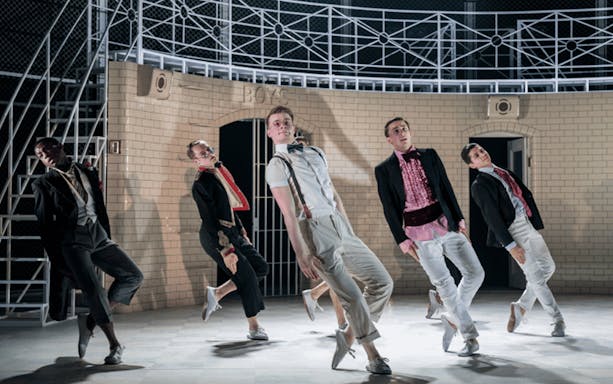 Dancers performing in Matthew Bourne's Romeo and Juliet against a brick backdrop.
