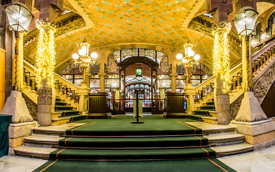 Palau de la Música Catalana interior with ornate staircase and stained glass.