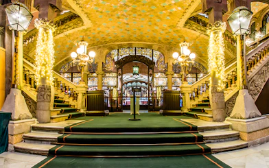 Palau de la Música Catalana interior with ornate staircase and stained glass.