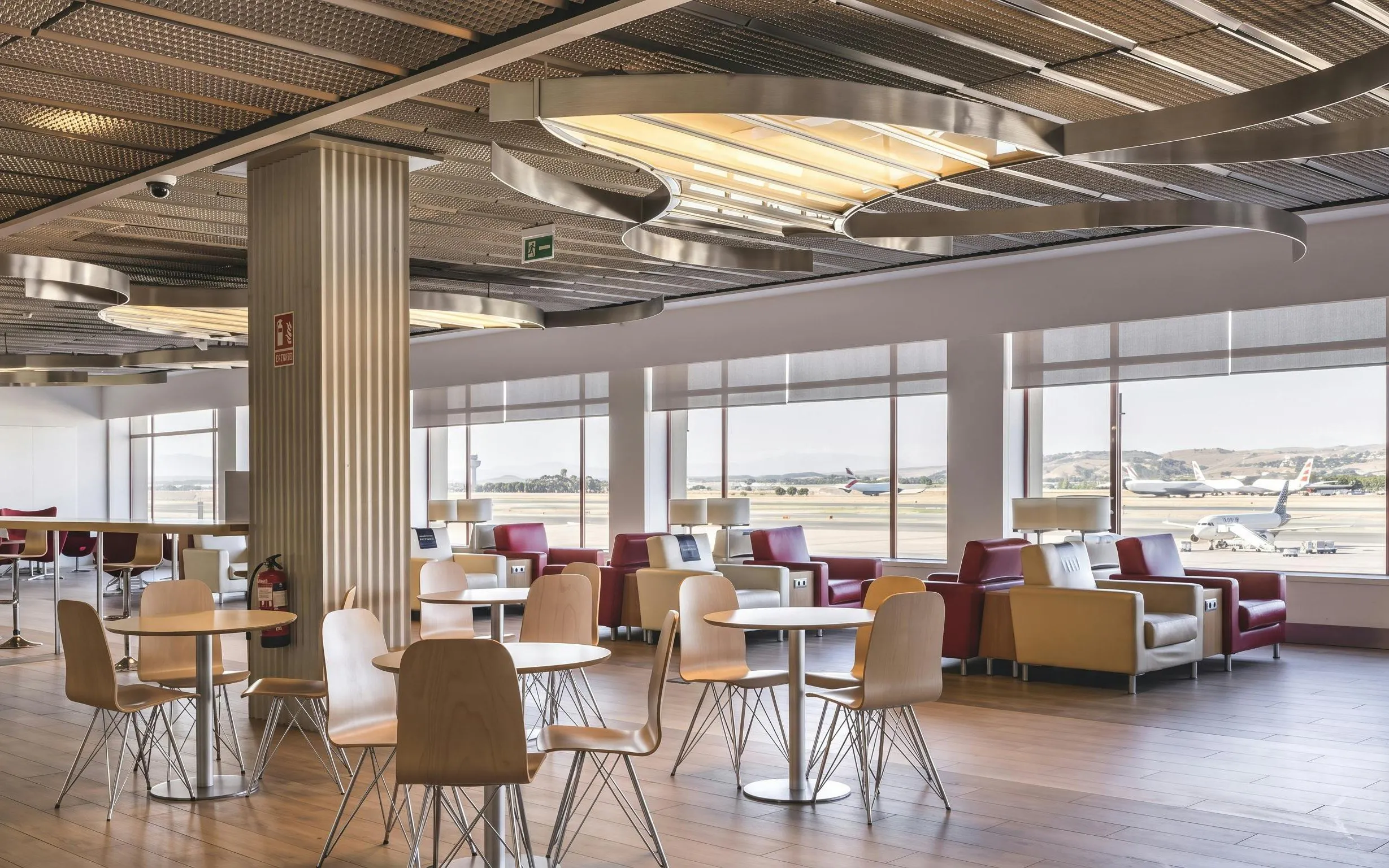 VIP lounge seating area at Adolfo Suarez-Barajas Airport, Terminal 2, Madrid with runway view.