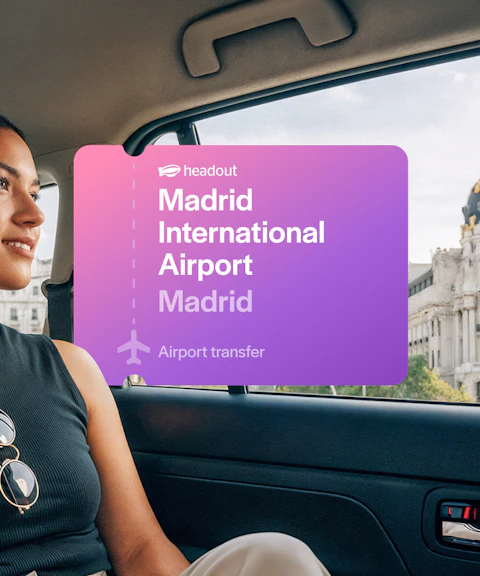 Passenger in car with view of Metropolis Building during Madrid airport transfer.