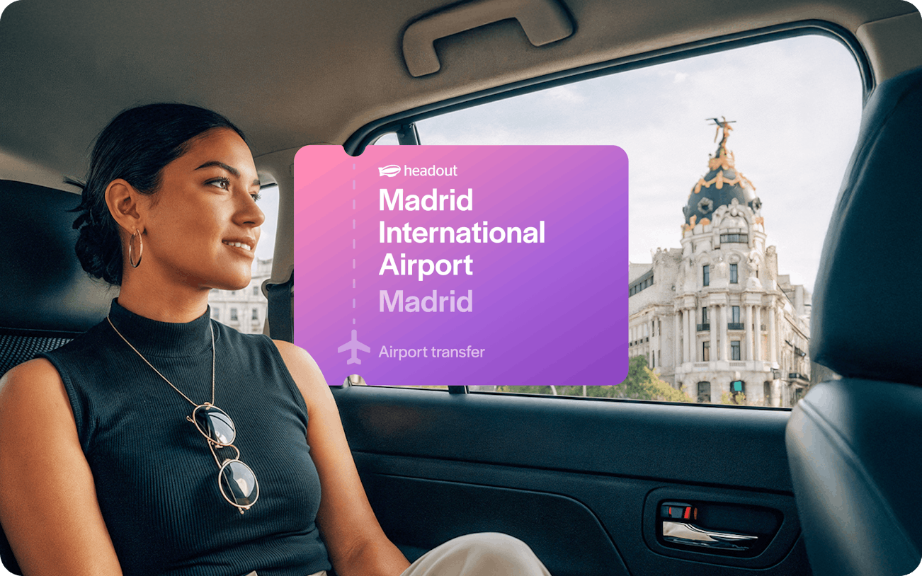 Passenger in car with view of Metropolis Building during Madrid airport transfer.