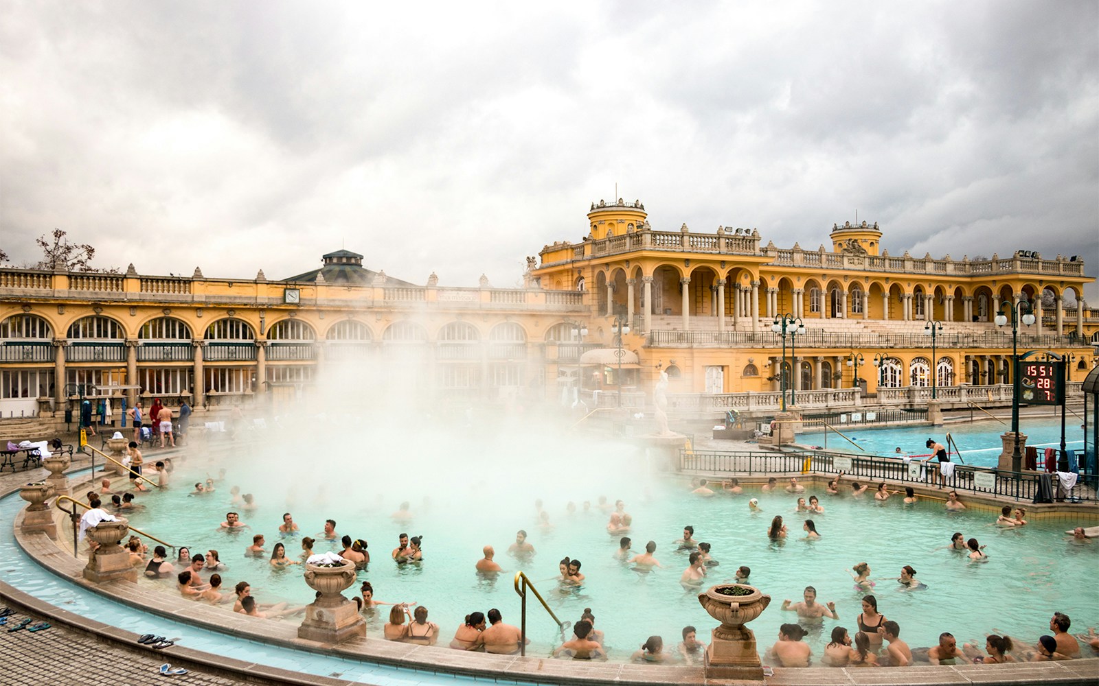 Thermal pools at Budapest baths with people relaxing and enjoying the historic architecture.
