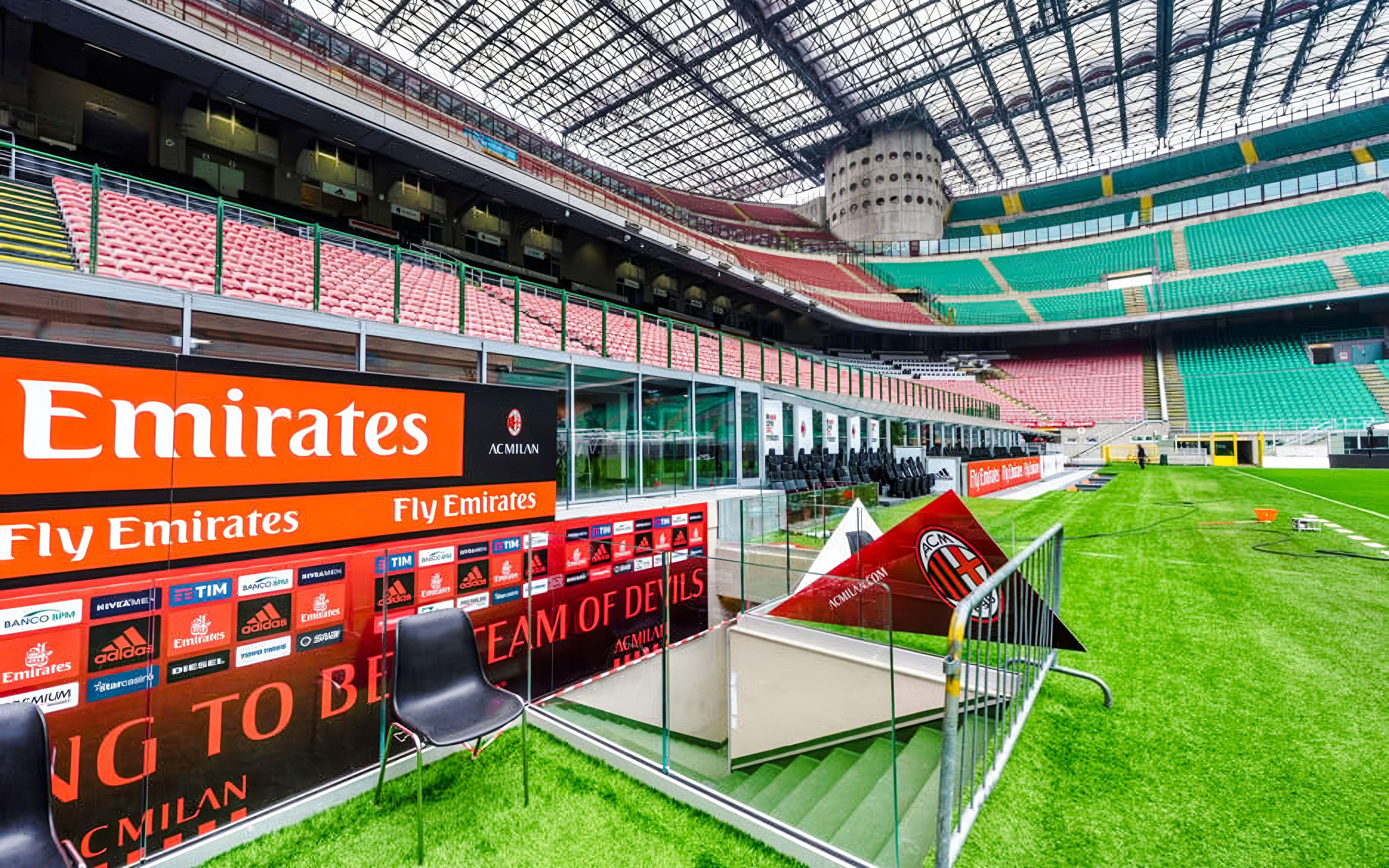 Players tunnel entrance at San Siro stadium with seating and advertising boards.