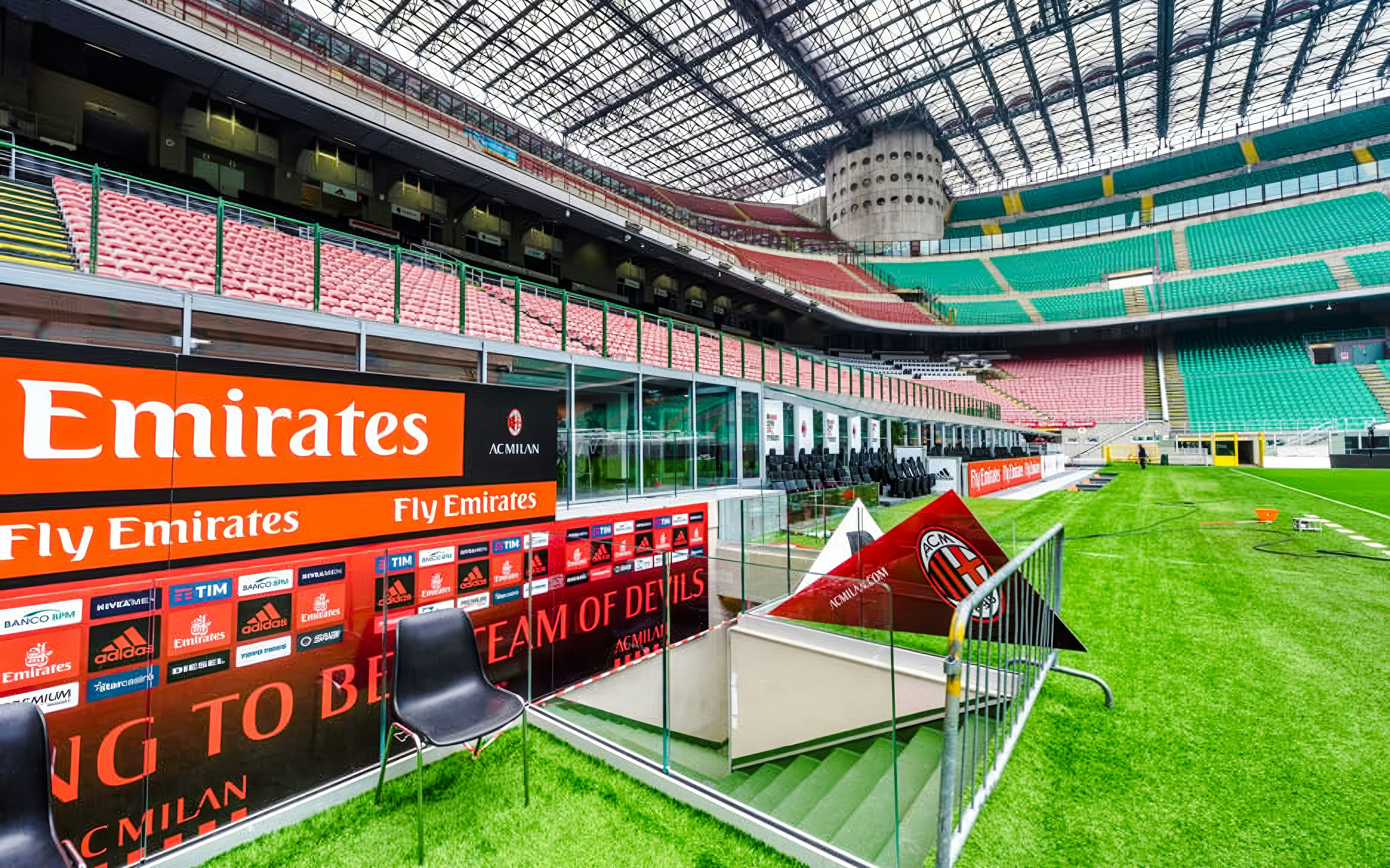 Players tunnel entrance at San Siro stadium with seating and advertising boards.