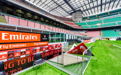 Players tunnel entrance at San Siro stadium with seating and advertising boards.