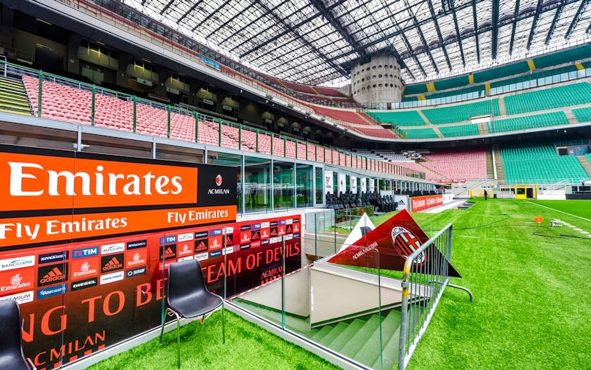 Players tunnel entrance at San Siro stadium with seating and advertising boards.
