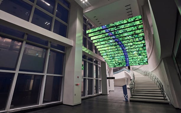 Interior view of Busan X The SKY with digital ceiling display and modern staircase.