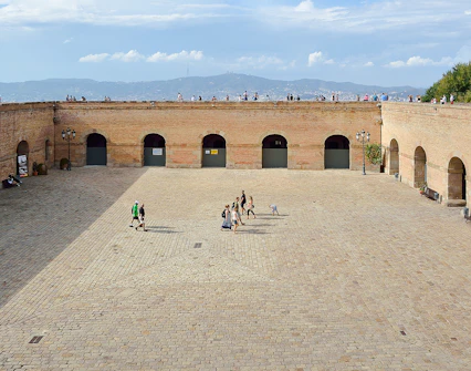 Montjuic Castle parade ground with visitors walking, Barcelona, Spain.