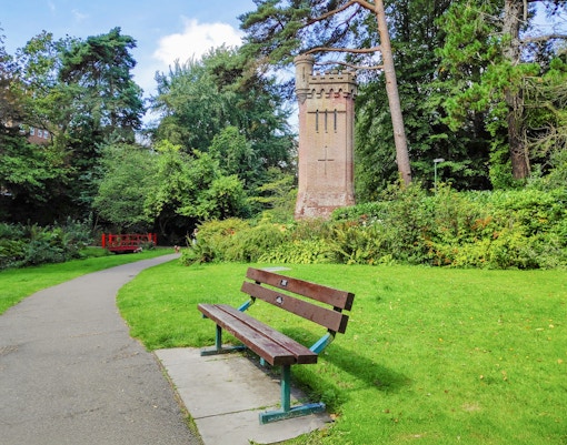 View of the green park with an empty bench, Bournemouth Upper Gardens
