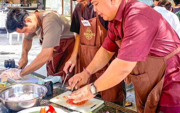 Participants chopping ingredients at Kekeb Balinese Cooking Class in Nusa Dua.