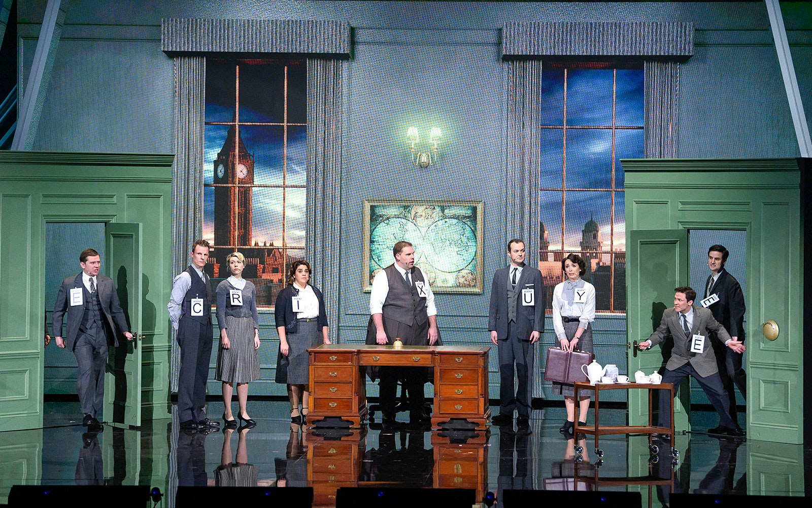 Actors on stage in a comedic spy play set in London, featuring Big Ben in the background.