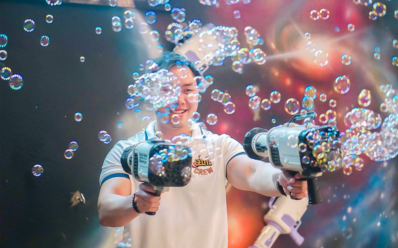 Person using bubble guns at The Selfie Experience in Phuket.