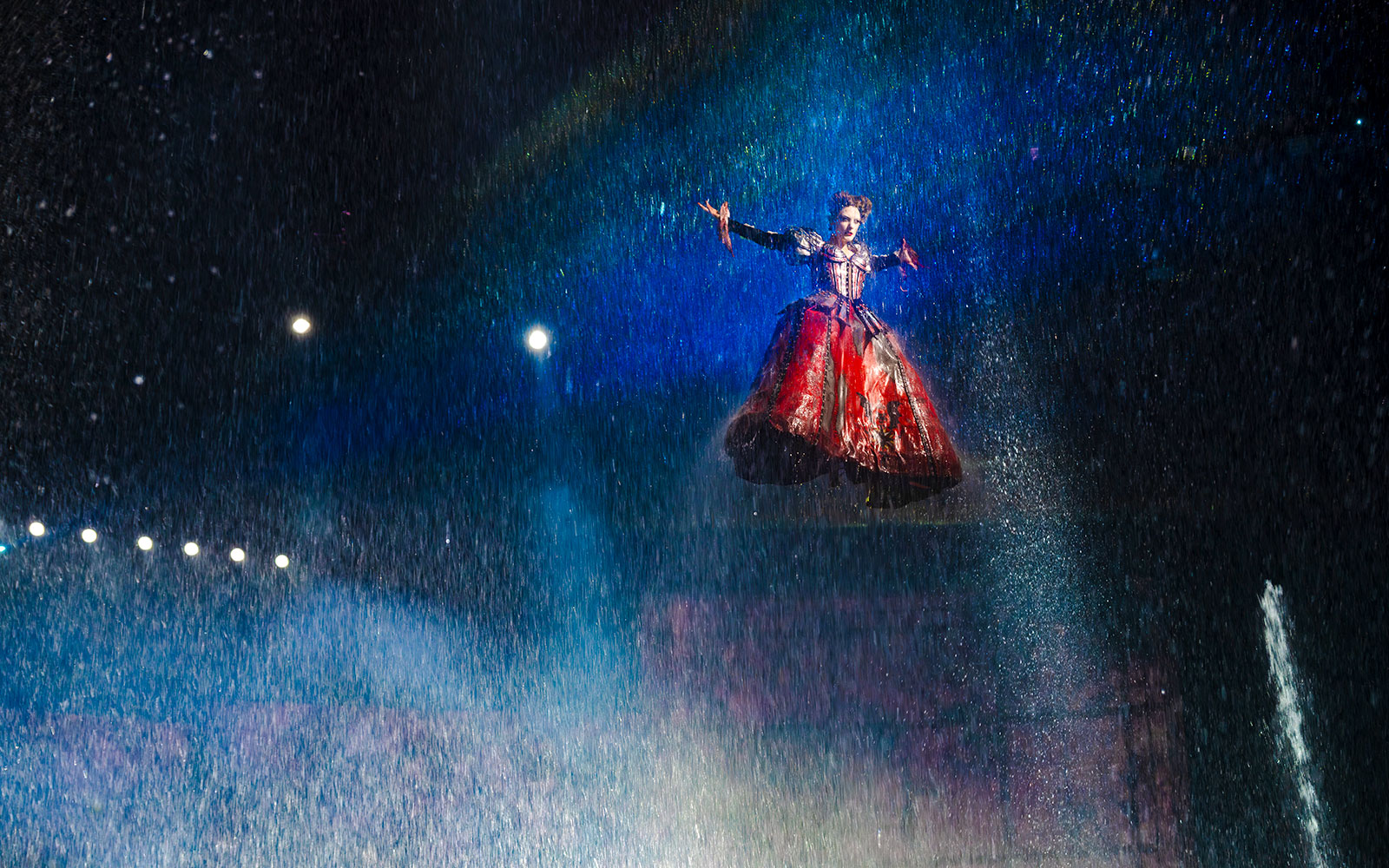 Performer suspended in air during House of Dancing Water show.