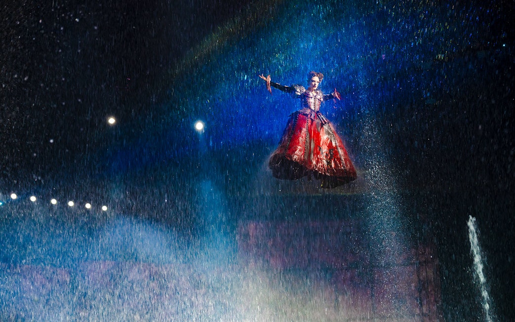 Performer suspended in air during House of Dancing Water show.