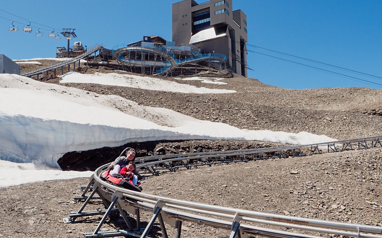 Tourist and child sliding down Alpine Coaster at Glacier 3000, Switzerland.