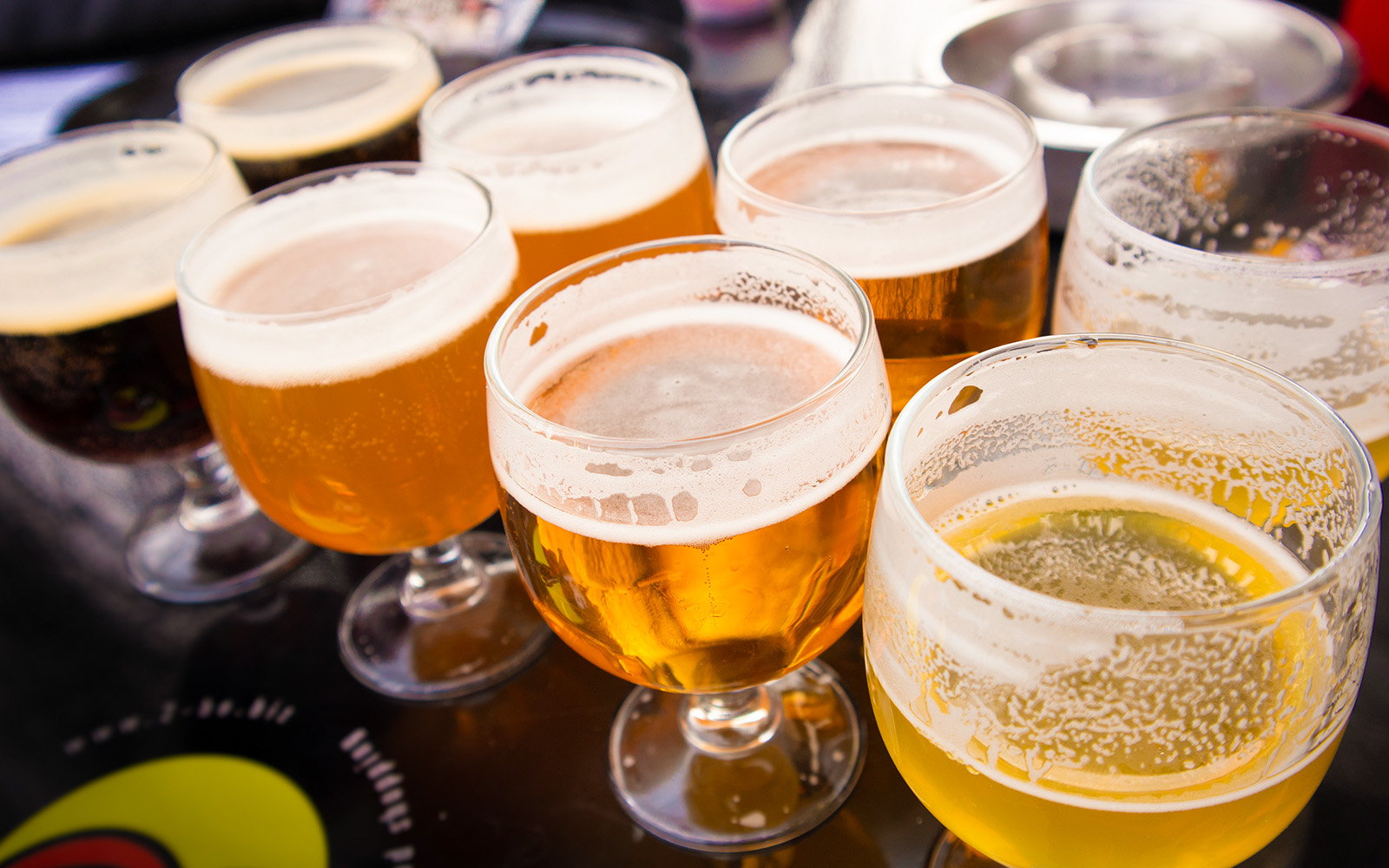 Assorted craft beers in glasses on a table at a brewery tour.