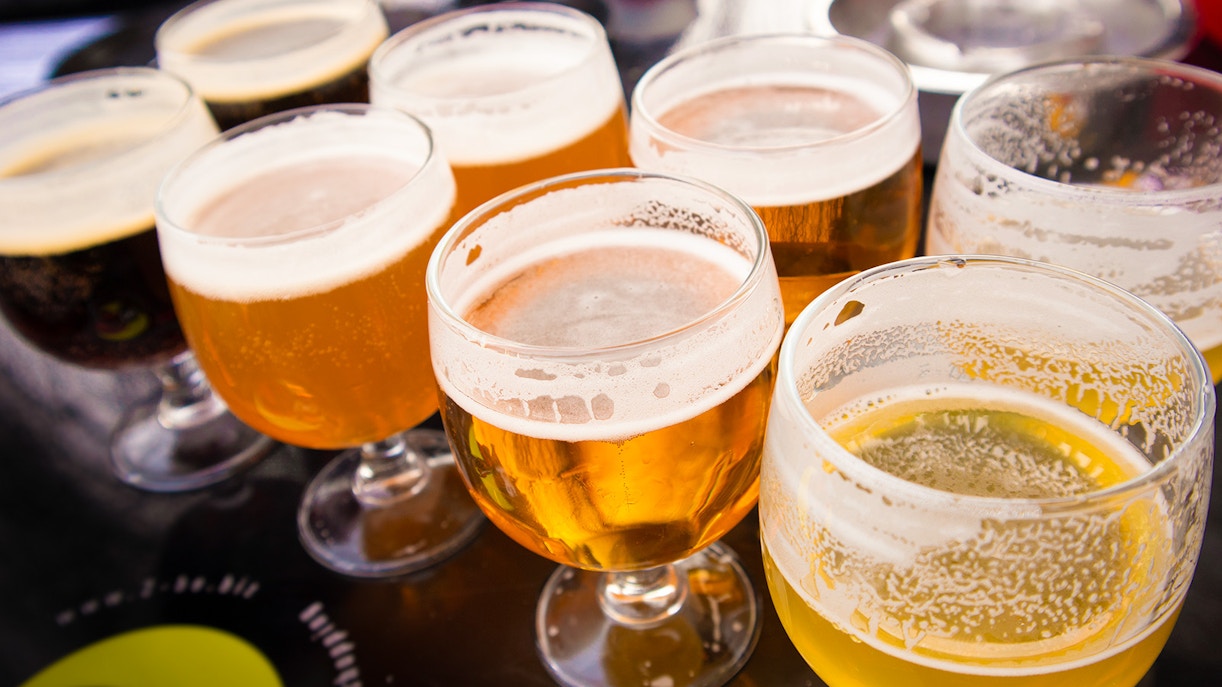 Assorted craft beers in glasses on a table at a brewery tour.