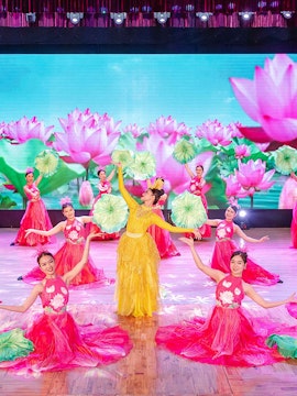 Performers in traditional Ao Dai costumes on stage in Da Nang show.