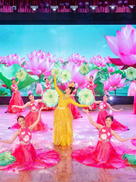 Performers in traditional Ao Dai costumes on stage in Da Nang show.
