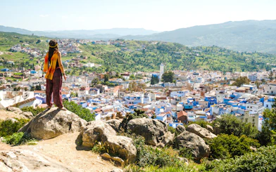 Traveler overlooking Chefchaouen, the blue city, from a hilltop in Morocco.