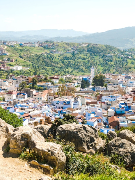 Traveler overlooking Chefchaouen, the blue city, from a hilltop in Morocco.