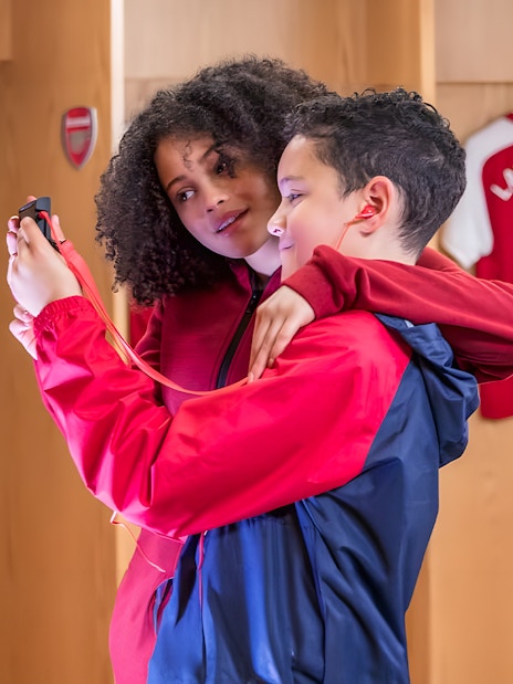 Children using audio guide in Arsenal FC Emirates Stadium locker room.