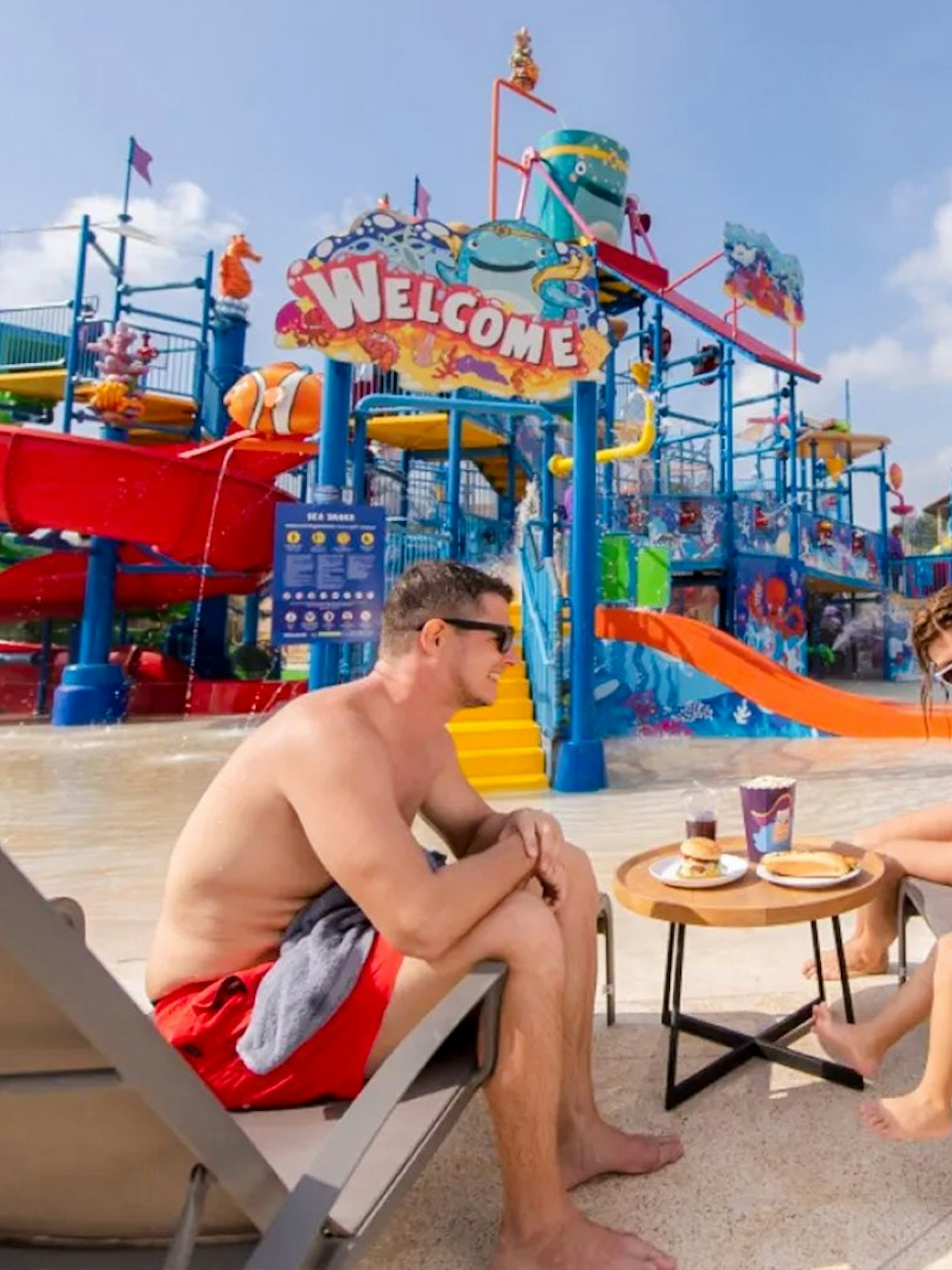 Family relaxing by water slides at Andamanda Phuket Water Park.